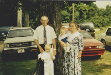 A face from a 1990s family snapshot at its original resolution, blurred into a few dozen pixels.
